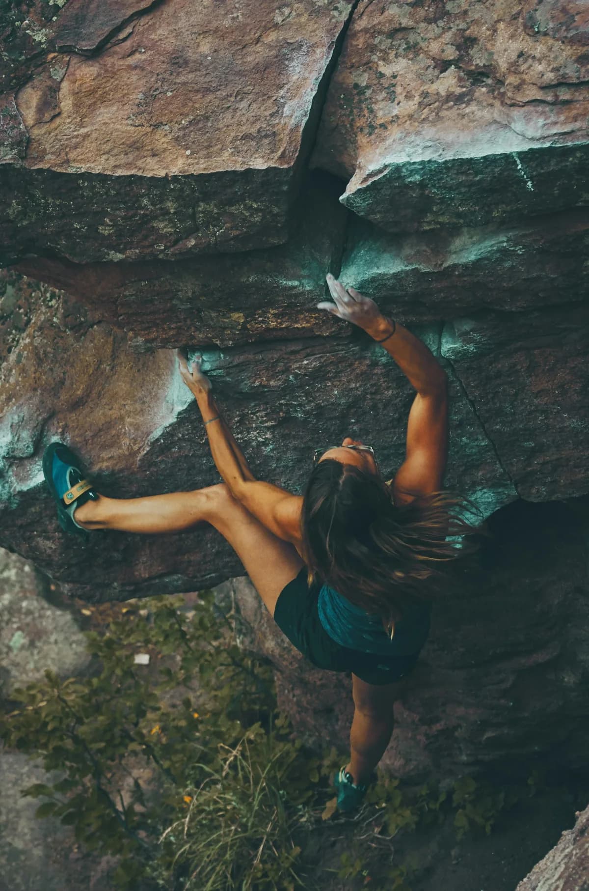Rock climber reaching for a hold mid-route, illustrating chiropractic support for athletic performance